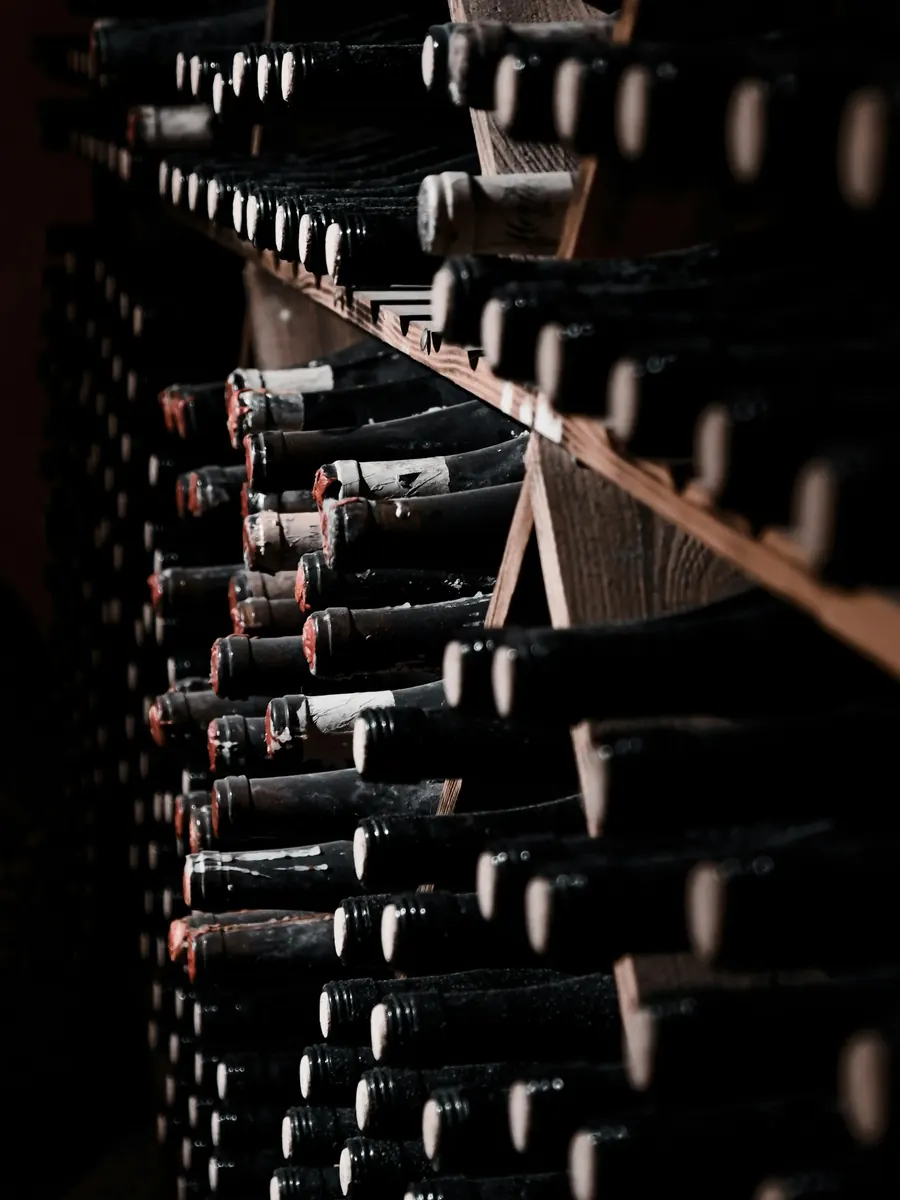 Bouteilles de crémant sur lattes dans une cave en tuffeau