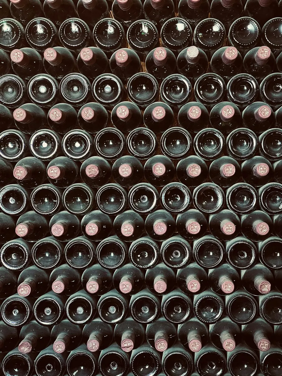 Casier rempli de bouteilles de vin vues de dos, sans étiquette visible