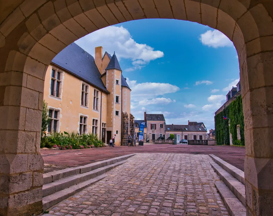 Porte discrète sur une cour pavée de vieille ville, pierre et colombages