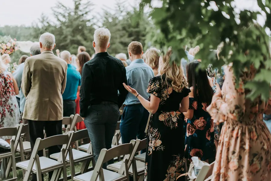 Invités debout de dos lors d'une cérémonie en plein air