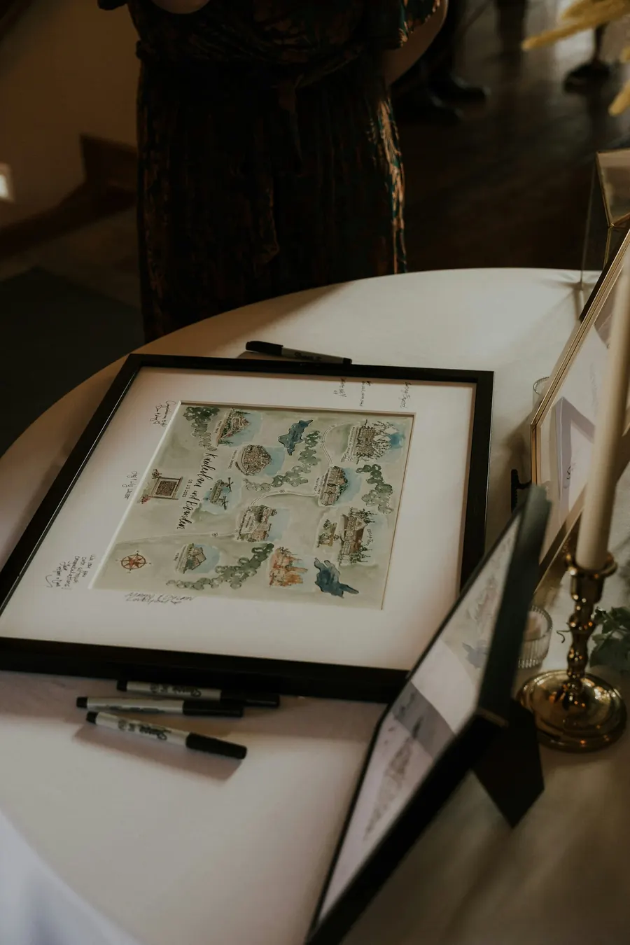 Plan illustré encadré posé sur une table, avec un stylo à côté
