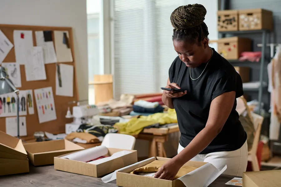 Créatrice photographiant ses produits dans son atelier