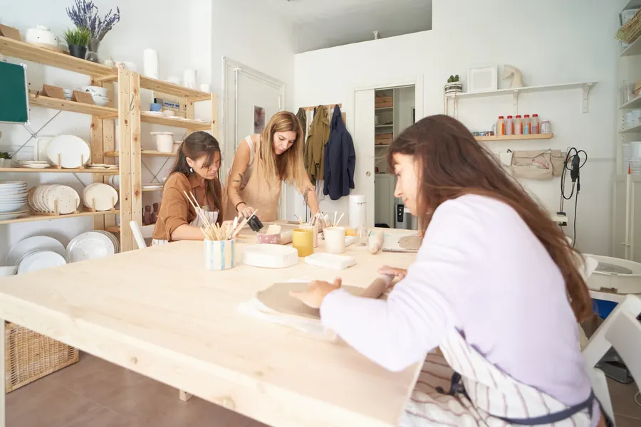 Atelier de poterie : une animatrice et ses élèves