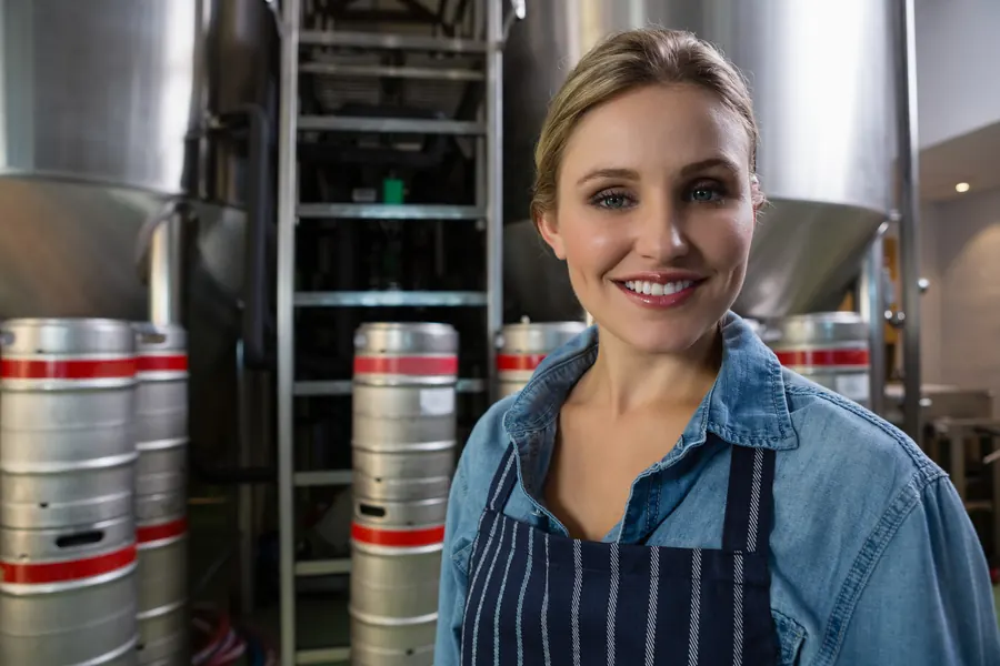 Brasseuse souriante devant ses cuves