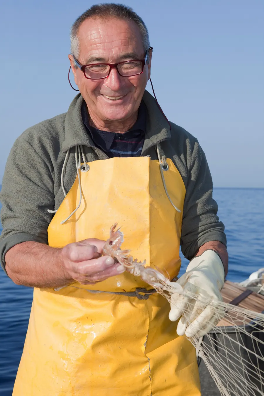 Marin-pêcheur souriant sur son bateau