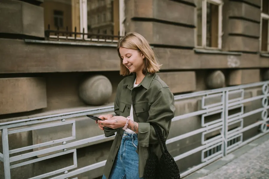 Femme consultant son smartphone en marchant dans la rue