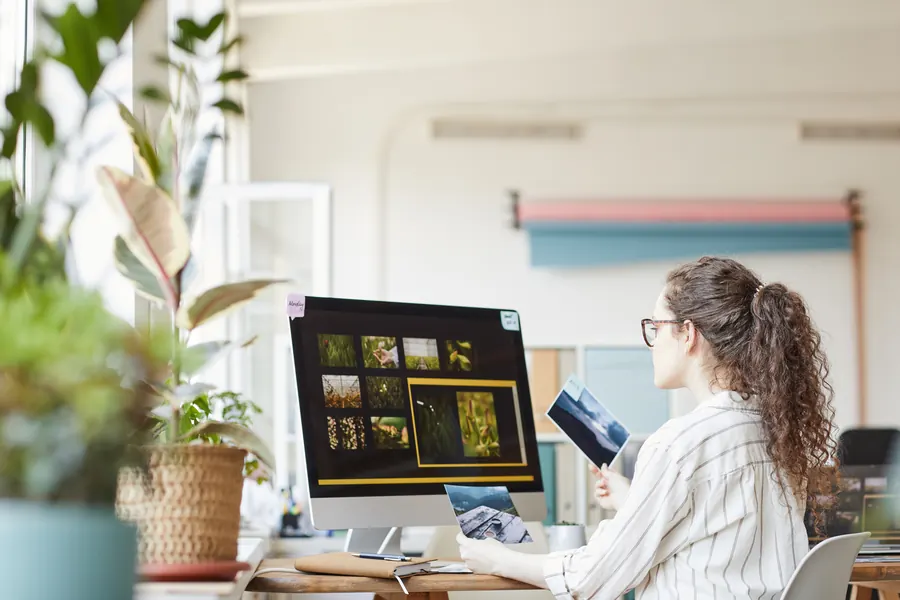 Une indépendante travaille à son bureau, entourée de plantes