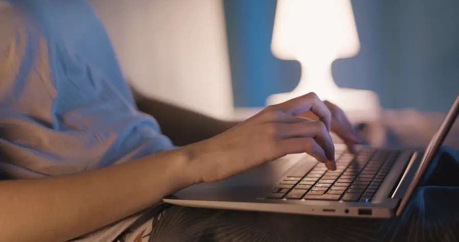 Mains qui tapent sur un clavier, le soir
