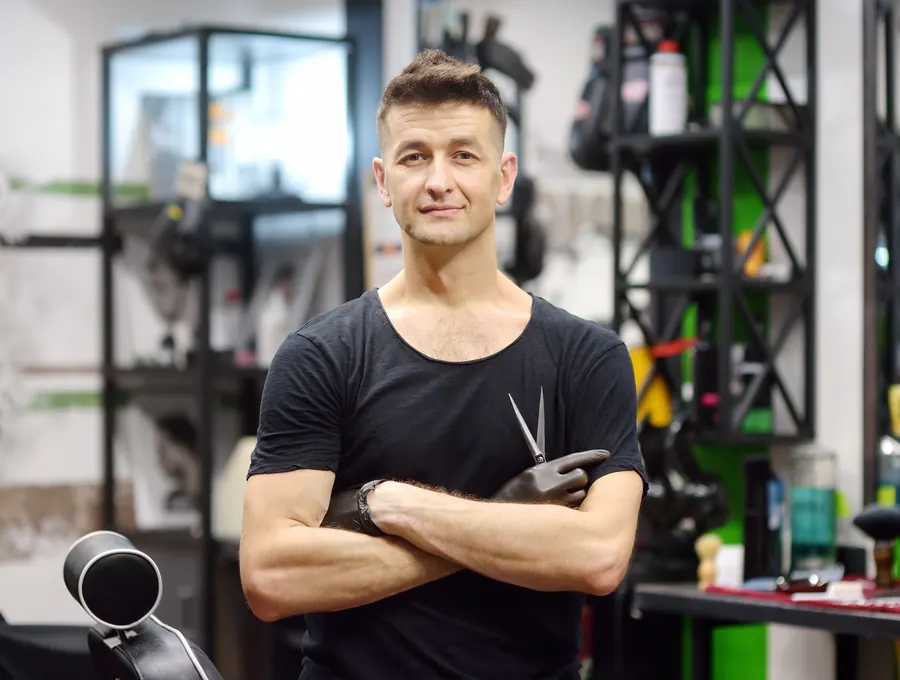 Un barbier dans son salon, ciseaux en main