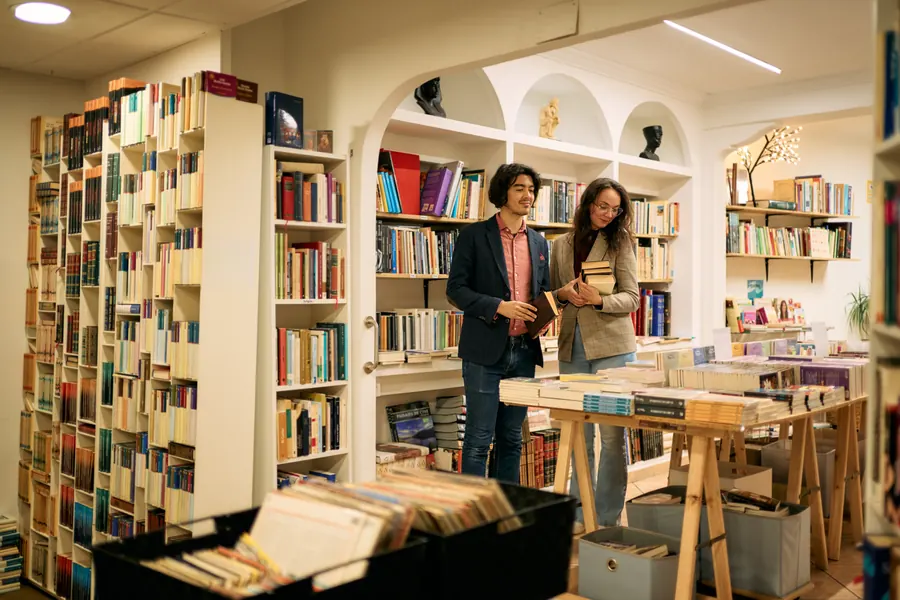 Un couple parcourt les rayons d'une librairie chaleureuse