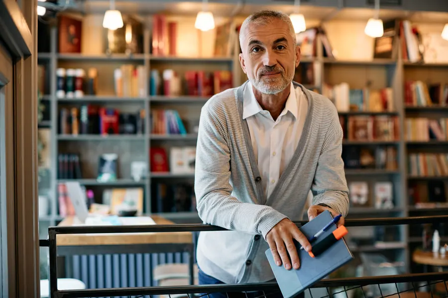 Un libraire aux cheveux gris, carnet en main