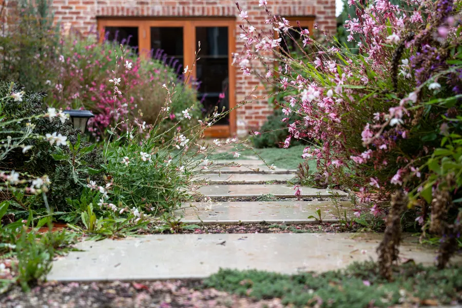 Une allée fleurie qui mène à une maison en briques