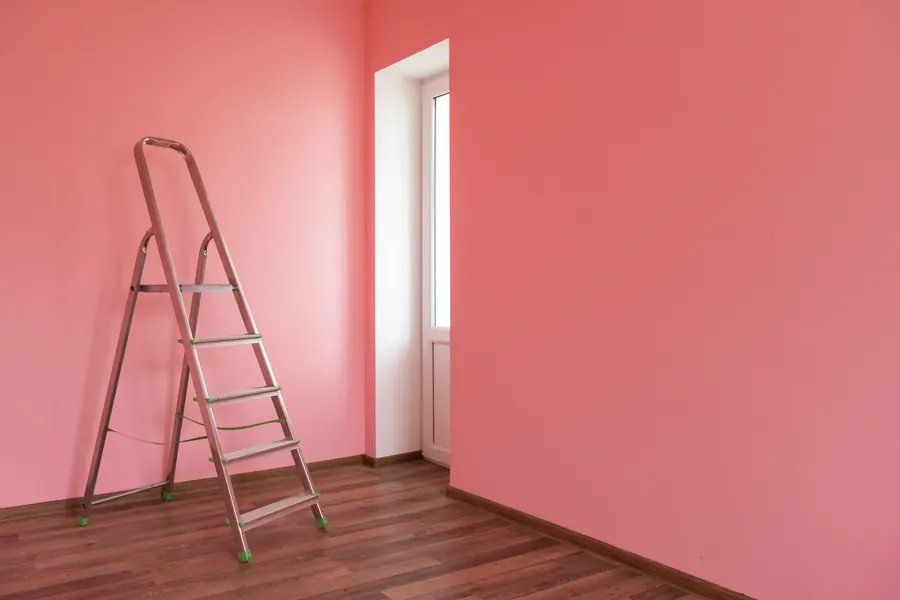 Une pièce repeinte en rose, échelle devant la fenêtre