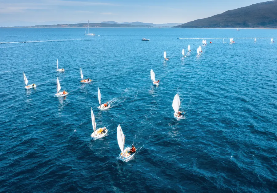 Des voiliers glissent sur une mer bleue et calme